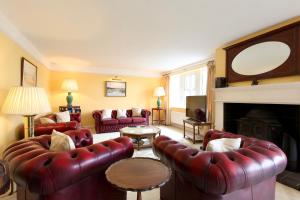 a living room with red leather furniture and a fireplace at Great Edge in Luddenden Foot