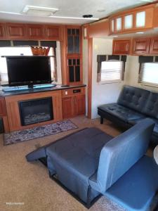 a living room with a couch and a tv at Mountain Camper at Howland's Hideout in Sampson