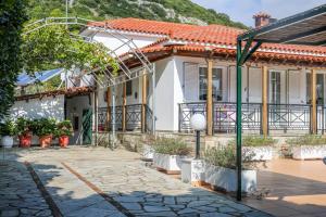 a house with a courtyard with potted plants at VILLA MITZELOS in Skiathos