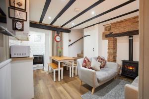 a living room with a couch a table and a fireplace at Host & Stay - Thimble Cottage in Whitby