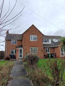 a brick house with a driveway in front of it at Very Spacious 4 Bedroom house with large garden in Leamington Spa