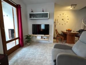 a living room with a couch and a tv and a table at Dúplex Bornoi in Vinarós