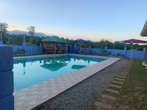 a swimming pool with blue water in a yard at Scarlett Near Mount Zion Laguit Padilla in Bugallon
