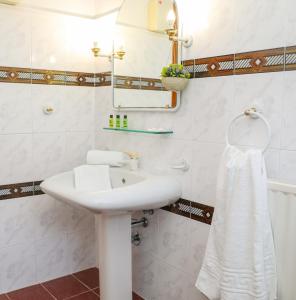 a bathroom with a white sink and a mirror at VILLA MITZELOS in Skiathos