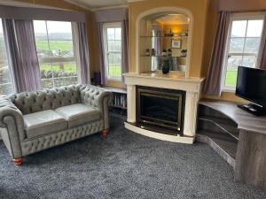 a living room with a couch and a fireplace at Bridge Farm Caravan in Buxton