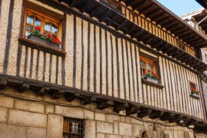 a building with two windows with flowers in them at La casona de la alberca in La Alberca