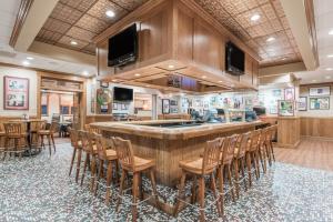 a large kitchen with a large bar with chairs at Ramada by Wyndham State College Hotel & Conference Center in State College