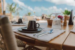 a table with a plate and a coffee cup on it at Ankura Preá Spa & Boutique Hotel in Cruz +61 photos