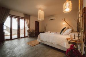 a bedroom with a large bed and a balcony at Ankura Preá Spa & Boutique Hotel in Cruz