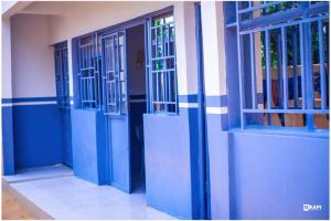 eine Reihe blauer Türen an einem Gebäude in der Unterkunft HÔTEL AMANI - Kikwit in Kizamba