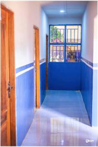 ein leerer Raum mit blauen Wänden und einer offenen Tür in der Unterkunft HÔTEL AMANI - Kikwit in Kizamba + 1 Foto
