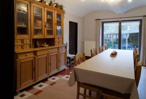a kitchen with a table and a large wooden cabinet at Le Relais du Malpas in Namur