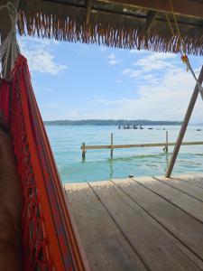 a view of the water from a hammock on a pier at Tio Toms Guesthouse in Bastimentos