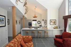 a kitchen with a bar and stools in a room at Kennels Cottage in Buchanty