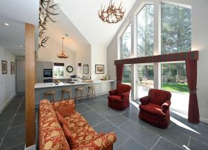 a living room with a couch and chairs and a kitchen at Kennels Cottage in Buchanty