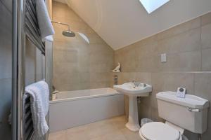 a bathroom with a sink and a toilet and a bath tub at Kennels Cottage in Buchanty +14 photos