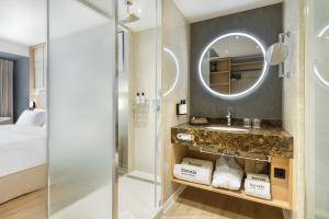a bathroom with a sink and a mirror at Barceló Dresden Newa in Dresden