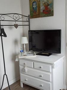 a white dresser with a tv on top of it at Magnolia in Trois-Palis