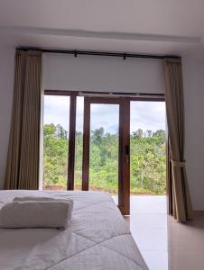 a bedroom with a bed and a large window at A'Resta Samasta Green Lodge in Praya