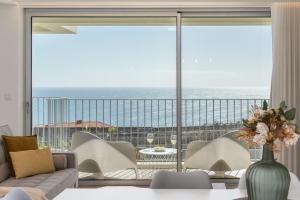 a living room with a view of the ocean at BAsia Apartment by An Island Apart in Funchal +26 photos