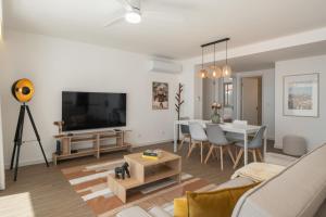 a living room with a couch and a tv and a table at BAsia Apartment by An Island Apart in Funchal