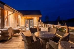 a patio with a table and chairs on a deck at Bears Den in Ilkley