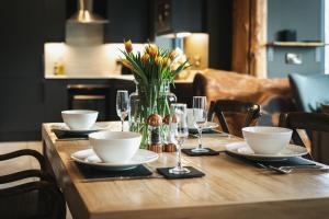 a wooden table with a vase of flowers on it at Bears Den in Ilkley