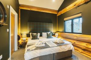 a bedroom with a large bed with two towels on it at Bears Den in Ilkley