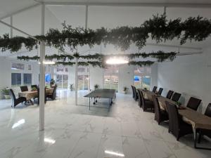 a room with a ping pong table and chairs at Pensiunea Aurelia in Bicaz Chei +45 photos