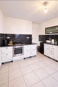 a kitchen with white cabinets and a stove at Monteurzimmer Saarland in Merchweiler