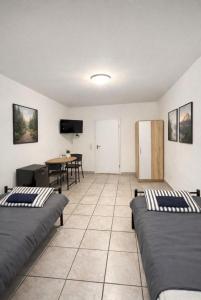 a room with two beds and a table at Monteurzimmer Saarland in Merchweiler