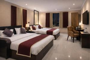 a hotel room with two beds and a desk at Pavitram Hotel & Banquet in Rānchī +134 photos