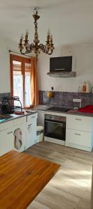 a kitchen with white cabinets and a stove top oven at Passage des Jardins in Sorède +15 photos