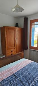 a bedroom with a bed and a wooden cabinet at Passage des Jardins in Sorède