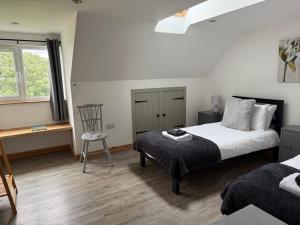 a bedroom with a bed and a chair and a window at Islecroft House Bed & Breakfast in Isle of Whithorn