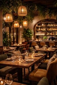 a restaurant with wooden tables and chairs and lights at Pavitram Hotel & Banquet in Rānchī