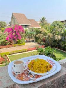 a plate of food on a table with a cup of coffee at Lonavala Golden Bird 3 bhk villa in Malavli