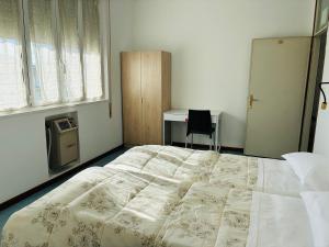ein Schlafzimmer mit einem großen Bett und einem Schreibtisch in der Unterkunft Hotel Riccò in Bagnolo San Vito