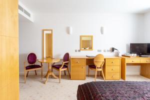 a room with a desk and chairs and a television at George Albert Hotel & Spa in Dorchester