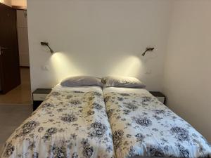 ein Schlafzimmer mit zwei Betten und zwei Wandlampen in der Unterkunft Hotel Riccò in Bagnolo San Vito