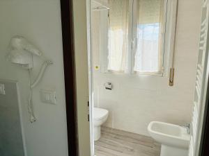 ein weißes Badezimmer mit Toilette und Waschbecken in der Unterkunft Hotel Riccò in Bagnolo San Vito