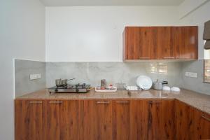 a kitchen with wooden cabinets and a counter top at BHRS Residency in Munnar
