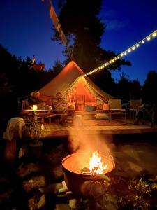 a tent with a fire in front of it at night at Vista Vibes Glamping in Grillby
