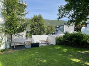 a yard with two benches and a fence at Tromsø Town and Nature in Trondalen
