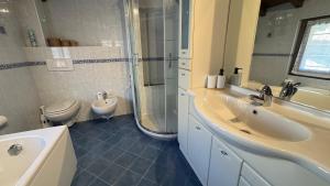 a bathroom with two sinks and a shower and a toilet at Casa Zia Pia in Baveno +23 photos