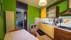 a kitchen with green and yellow walls and a counter at Casa Zia Pia in Baveno
