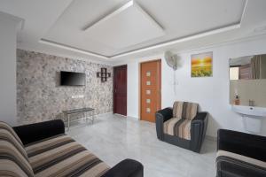 a living room with two couches and a tv at BHRS Residency in Munnar