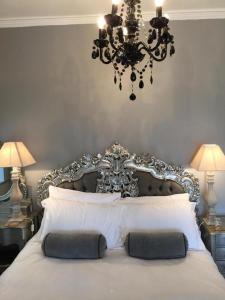 a bedroom with a large white bed with a chandelier at The White House Hotel in Newquay