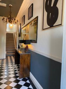 a hallway with a table and a checkerboard floor at The White House Hotel in Newquay
