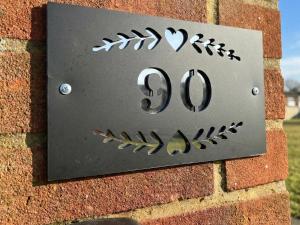 a sign on the side of a brick wall at 90 Bay View in New Romney